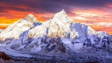 Alt text: Vibrant Nepal: Majestic Himalayas, prayer flags, bustling streets, traditional architecture at sunrise.