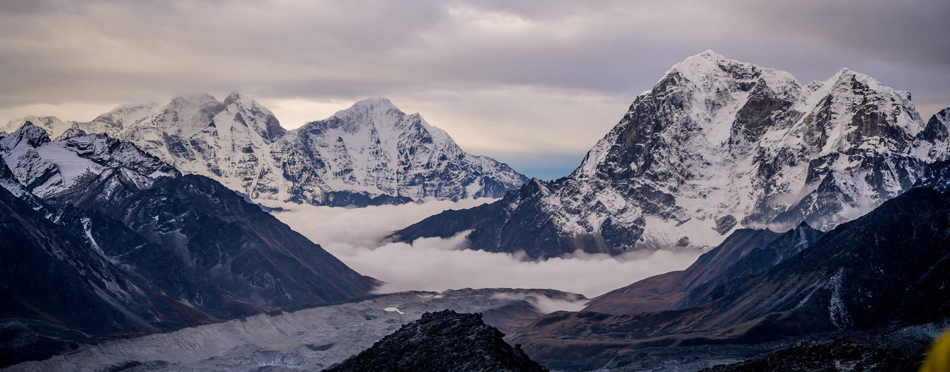 a mountain range with clouds and snow