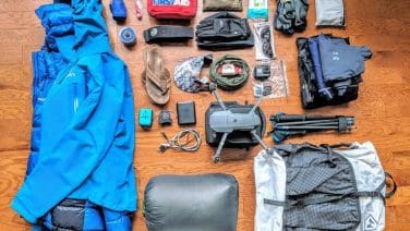 Alt text: A group of trekkers in Nepal with essential gear, against Himalayan mountains backdrop.