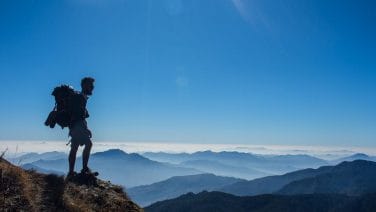 Hikers at Himalaya base with Everest and Nepalese cultural highlights in a vibrant photo.