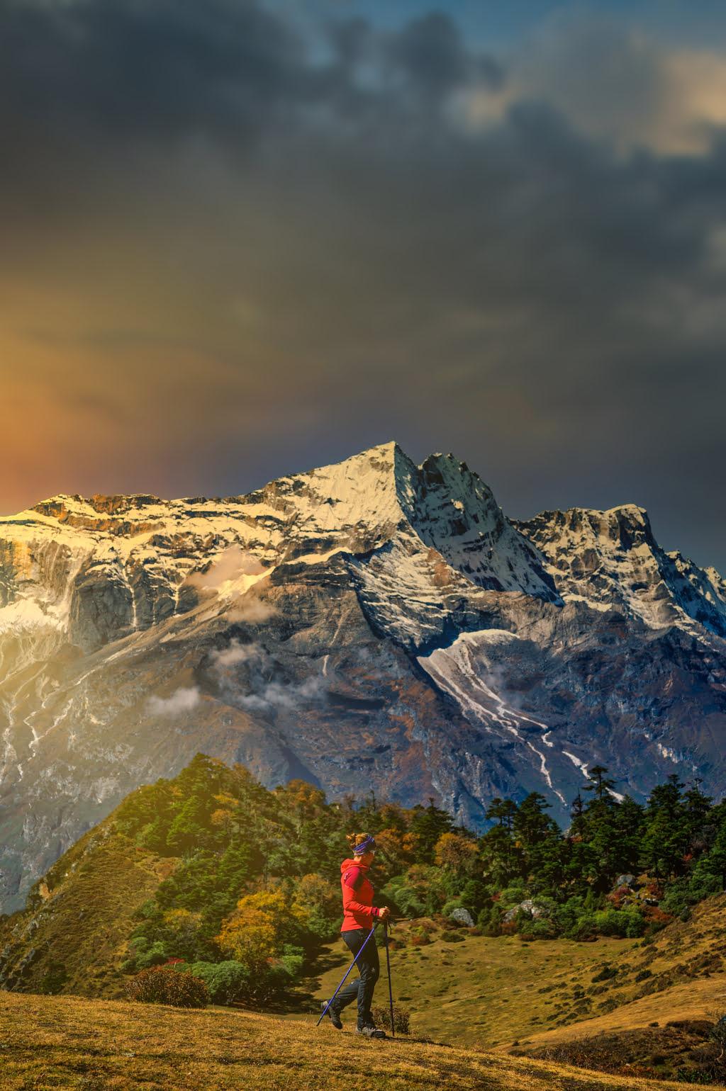 Solo traveler stands contemplatively by a serene lake, Himalayas towering in the background.