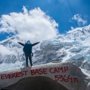 Trekker standing at Everest Base Camp with Himalayan peaks in the background, Nepal trekking adventure