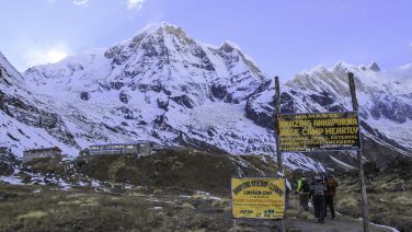 Trekkers approaching Annapurna Base Camp beneath clear November skies