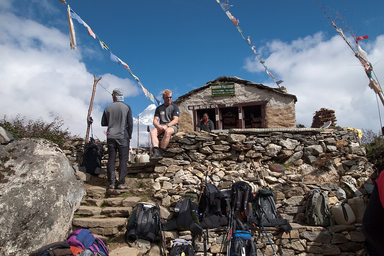 Trekkers resting outside a stone teahouse at Phortse Tenga, Nepal